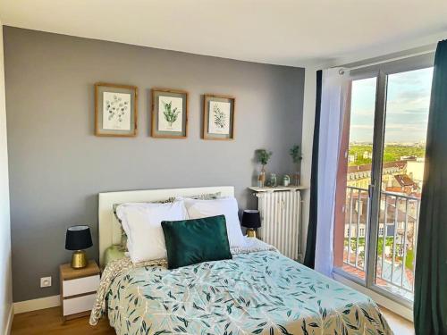 サン・ジェルマン・アン・レーにあるAppartement spacieux hyper centre Saint Germainのベッドと大きな窓のある寝室
