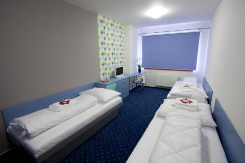 a hotel room with two beds and a window at Hotel Galaxie in Zlín