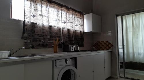 a kitchen with a washing machine on a counter at Limbila House in Cape Town