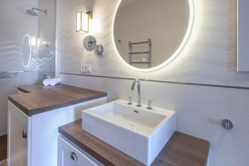 a bathroom with a white sink and a mirror at BalaLake Resort in Szántód