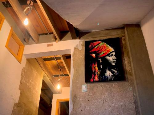 a painting of a woman hanging on a wall at Amuya Hostel in Chiquinquirá