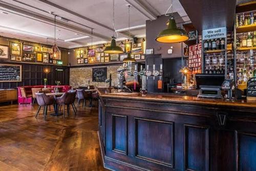 a pub with a bar with tables and chairs at Elegant & spacious parkside 2-bedroom 2-bathroom flat in period building facing Blackheath - parking, great Greenwich location, easy for O2 Arena and City, very near Marathon start line! in London