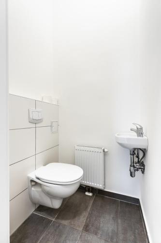 a white bathroom with a toilet and a sink at Stylish designed apartment in a top location in Vienna
