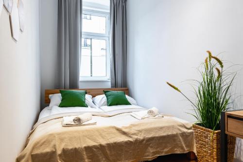 a bedroom with a bed with green pillows and a window at Stylish designed apartment in a top location in Vienna