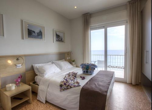a hotel room with a bed and a large window at Hotel La Baia in Diano Marina