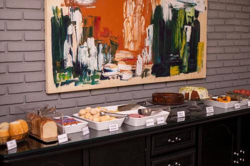 a table with food on it with paintings on the wall at Premier Hotel in Votuporanga