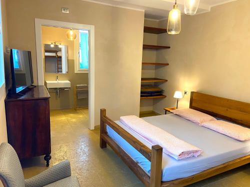 a bedroom with a bed and a television and a sink at Rio Sabbioso in Dozza