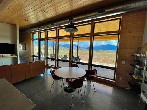 a dining room with a table and chairs and windows at Antelope Run - The Bunk House in Livingston