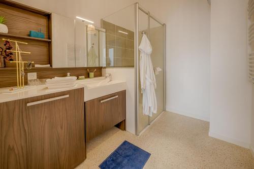 La salle de bains est pourvue d'un lavabo et d'une douche avec un miroir. dans l'établissement DOMITYS Le Piano Résidence Sénior, à Lille