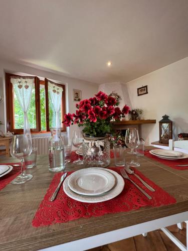 Il Bosco e Il Borgo Guest House Subiaco في سوبياكو: طاولة غرفة الطعام مع طبق أبيض ومنديل احمر