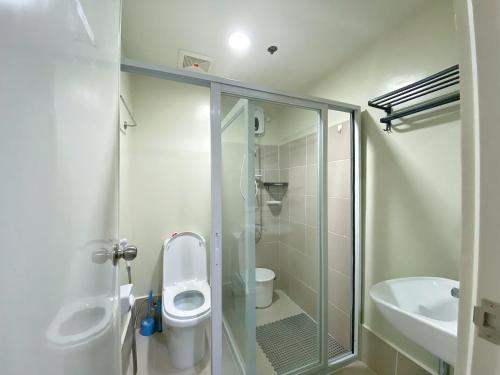 een badkamer met een douche, een toilet en een wastafel bij Cool Breeze Brenthill Deluxe in Baguio