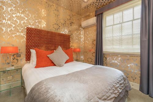 a bedroom with a large bed with orange pillows at Blanch House in Brighton & Hove