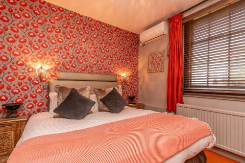 a bedroom with a bed and a red wall at Blanch House in Brighton & Hove