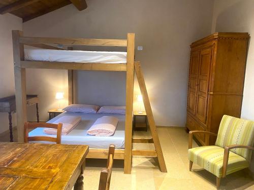 a room with a bunk bed and a table and a dining room at Rio Sabbioso in Dozza