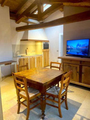 a kitchen with a wooden table and a tv at Rio Sabbioso in Dozza