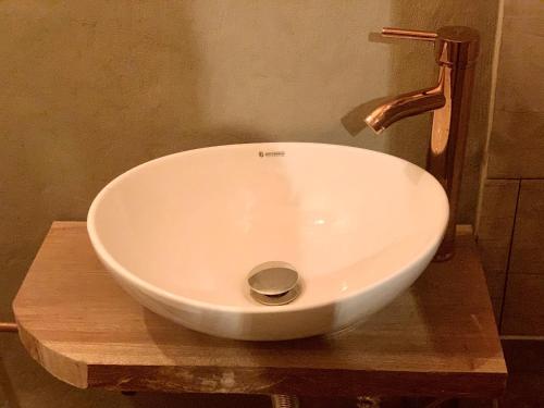 - un lavabo blanc assis au-dessus d'une table en bois dans l'établissement Amuya Hostel, à Chiquinquirá