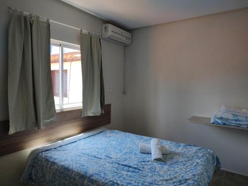 a small bedroom with a bed with a window at Apart. japaratinga in Japaratinga