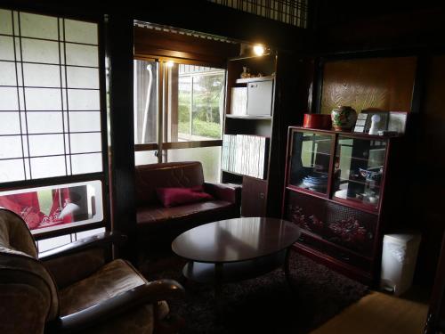 a living room with a couch and a coffee table at 駅前宿舎 禪 shared house zen in Eiheiji