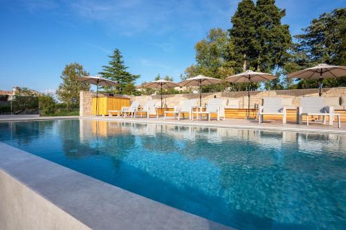 basen z krzesłami i parasolami w obiekcie Restaurant & Villa Morgan w mieście Brtonigla