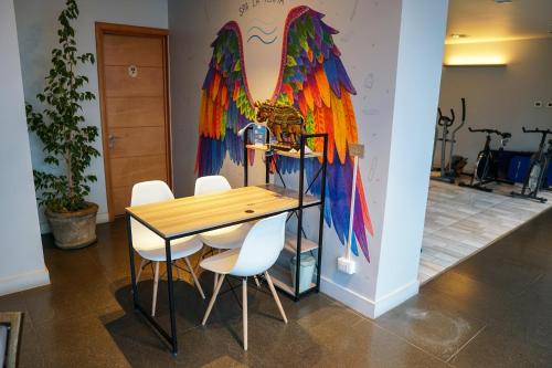 リナレスにあるHotel Parada Linaresのカラフルな壁の客室で、テーブルと椅子が備わります。