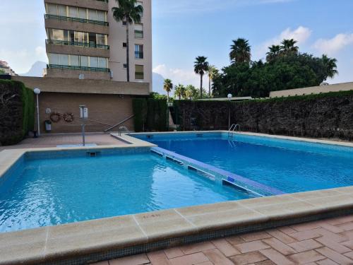 Una gran piscina azul al lado de un edificio en Casita Bonita, en Calpe