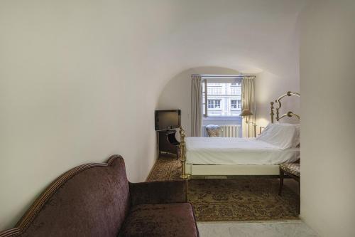 um quarto com uma cama, um sofá e uma janela em Garibaldi Glamorous Apartment by Wonderful Italy em Gênova