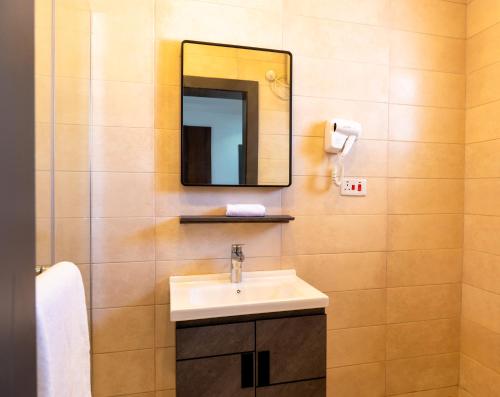 a bathroom with a sink and a mirror at Jotani Living in Lagos