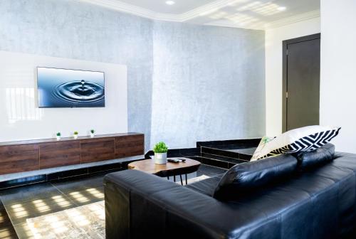 a living room with a black leather couch and a table at Jotani Living in Lagos
