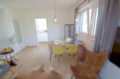 a dining room with a table and yellow chairs at stilvolle Wohnung direkt in der City in Würzburg