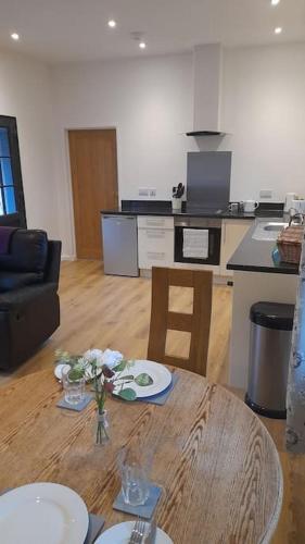 a living room with a table and a kitchen at Thornmoor Barn in Lifton