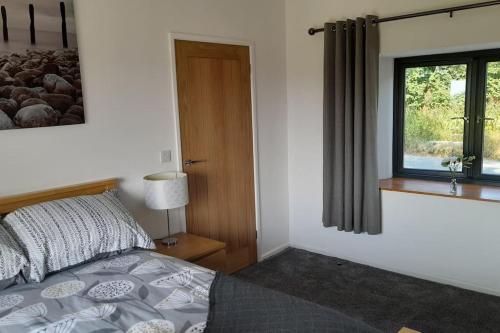 sypialnia z łóżkiem i oknem w obiekcie Thornmoor Barn w mieście Lifton