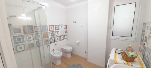 een witte badkamer met een toilet en een douche bij Appartamento 2 con piscina in Caltagirone