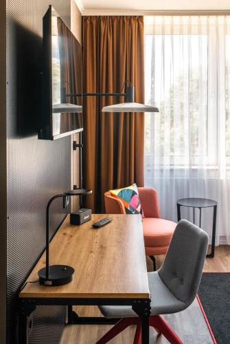 a living room with a table and a chair at Pentahotel Bremen in Bremen