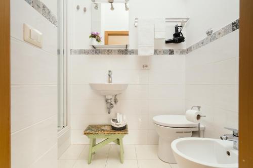 Baño blanco con lavabo y aseo en B&B La Finestra Sul Campanile, en Montecosaro
