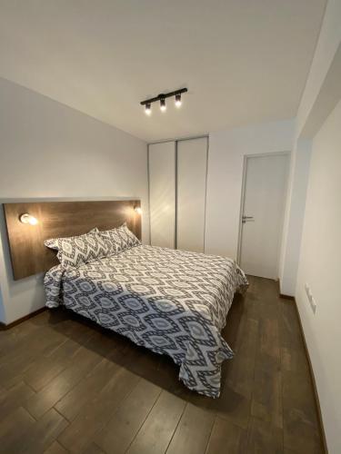 a bedroom with a bed and a wooden floor at Estudio completo en zona centro, a 200 metros del rio in Rosario