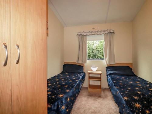 two beds in a small room with a window at Night Sky Delight in Launceston