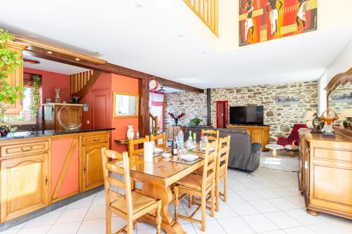 une cuisine avec une table et des chaises en bois dans l'établissement La Melorienne, à Saint-Méloir-des-Ondes