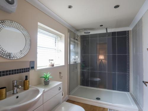 a bathroom with a shower and a sink at Ty Bach Twt in Amlwch