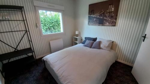 ein Schlafzimmer mit einem weißen Bett und einem Fenster in der Unterkunft Studio Privé Dijon in Dijon