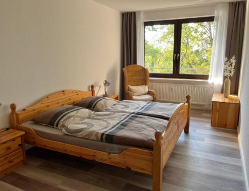 バート・ザルツフレンにあるAppartementresidenz am Kurpark - Ferienwohnungen mit Pool & Saunaのベッドルーム1室(木製ベッド1台、椅子、窓付)