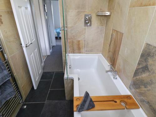 a bathroom with a bath tub and a shower at Olive Tree Cottage in Holmfirth