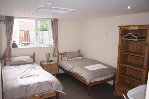 two beds in a small room with a window at Twin Bays in Hedon