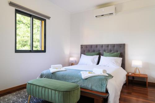 sypialnia z dużym łóżkiem i zieloną otomaną w obiekcie A Casa da Inês w mieście São Vicente Ferreira