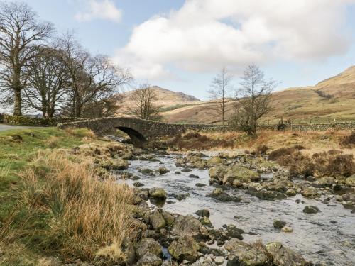 a bridge over a river in a field at Grizedale in Kendal