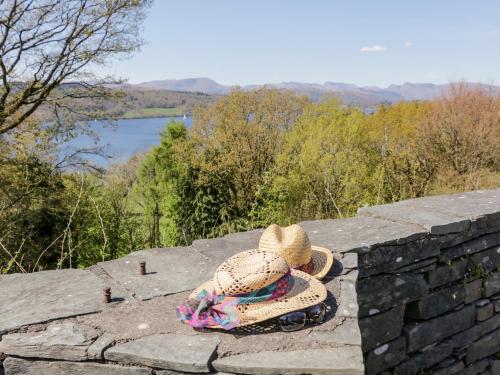a hat sitting on a stone wall with a view at Grizedale in Kendal