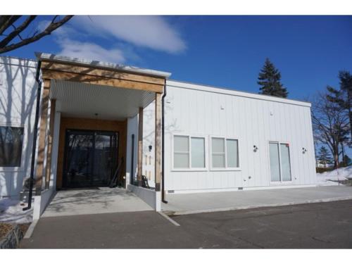 a large white building with a large door at Sarabetsu-mura chiiki Kouryu Center - Vacation STAY 31493v in Naka-satsunai