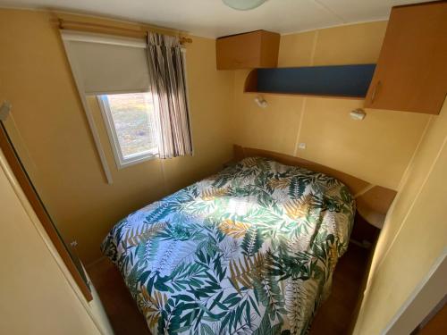a small bedroom with a bed in a small room at Domaine de Labelo in Commensacq
