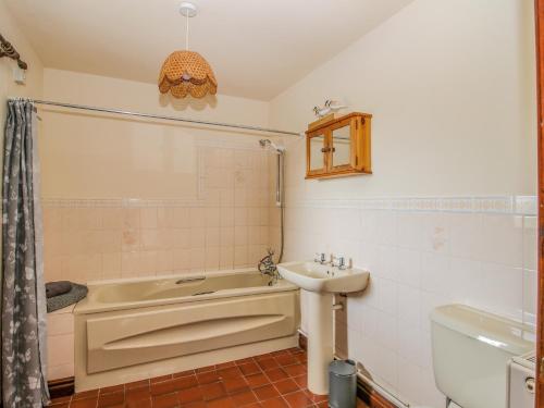 uma casa de banho com uma banheira e um lavatório em Owlbury Hall Barn em Montgomery