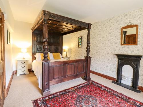 a bedroom with a large wooden bed and a fireplace at Gwengraig in Dolgellau
