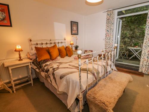 Lily Pad في أوكهامبتون: غرفة نوم مع سرير مع وسائد برتقالية ونافذة